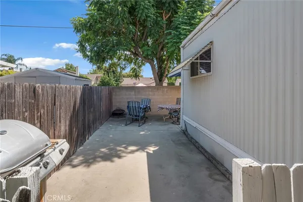 a backyard of a house with chairs and a tree