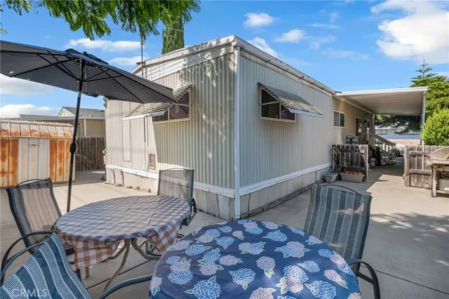 a roof deck with table and chairs under an umbrella