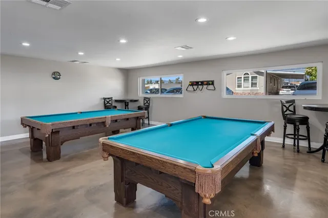 a room with pool table and windows