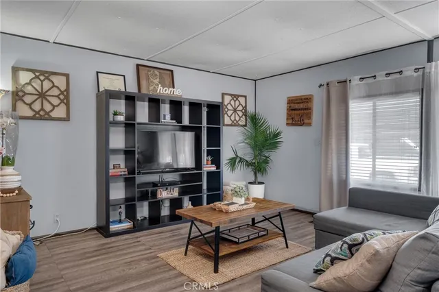 a living room with furniture a window and a flat screen tv