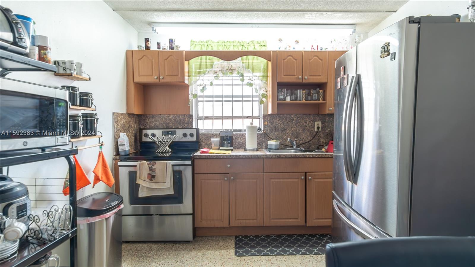 23 West 13th Street Hialeah, FL 33010 - Photo 44 of 54 a kitchen with stainless steel appliances granite countertop a refrigerator and a stove