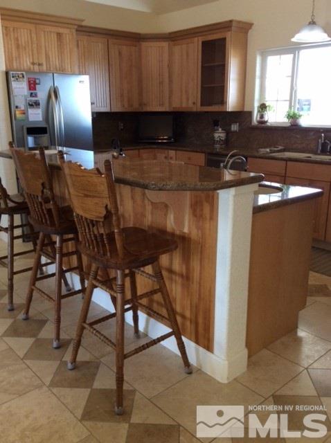 3950 Schindler Road Fallon, NV 89406 - Photo 10 of 24 a kitchen with a sink a refrigerator and chairs
