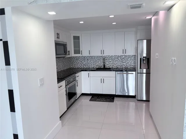 a kitchen with stainless steel appliances a refrigerator sink and microwave