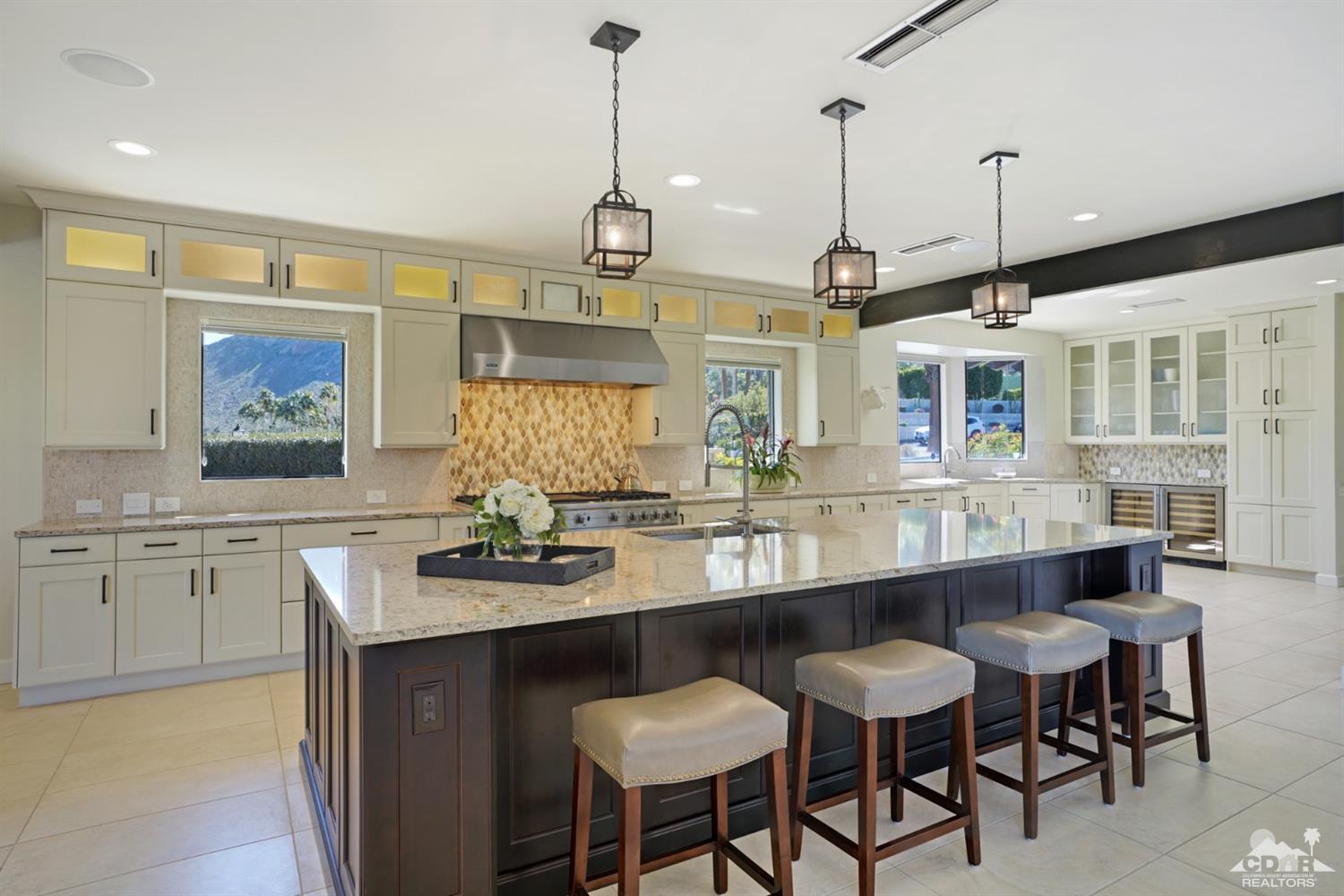 40757 Thunderbird Road Rancho Mirage, CA 92270 - Photo 28 of 70 a kitchen with stainless steel appliances granite countertop a sink a stove a dining table and chairs