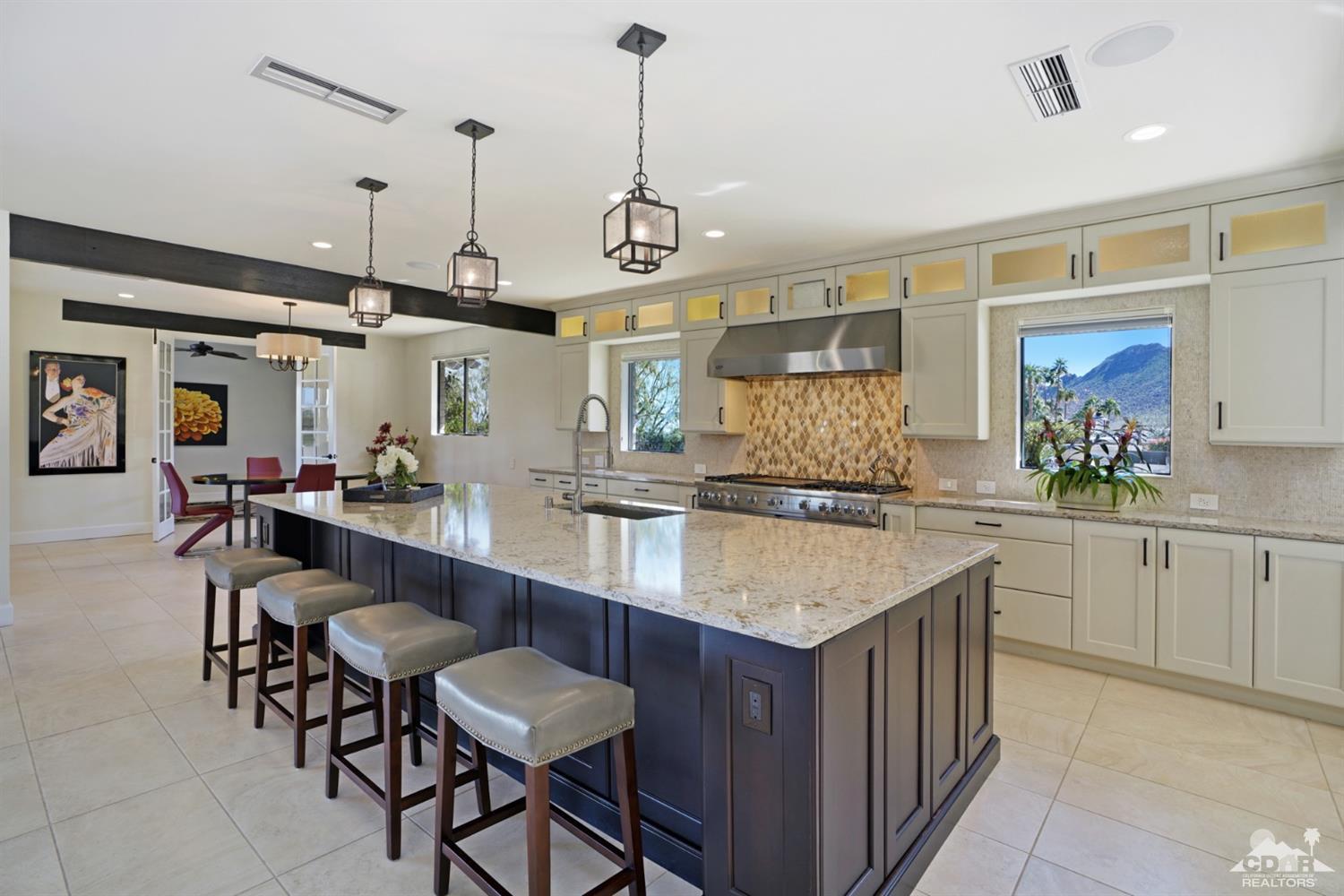 40757 Thunderbird Road Rancho Mirage, CA 92270 - Photo 29 of 70 a kitchen with center island table and chairs in it