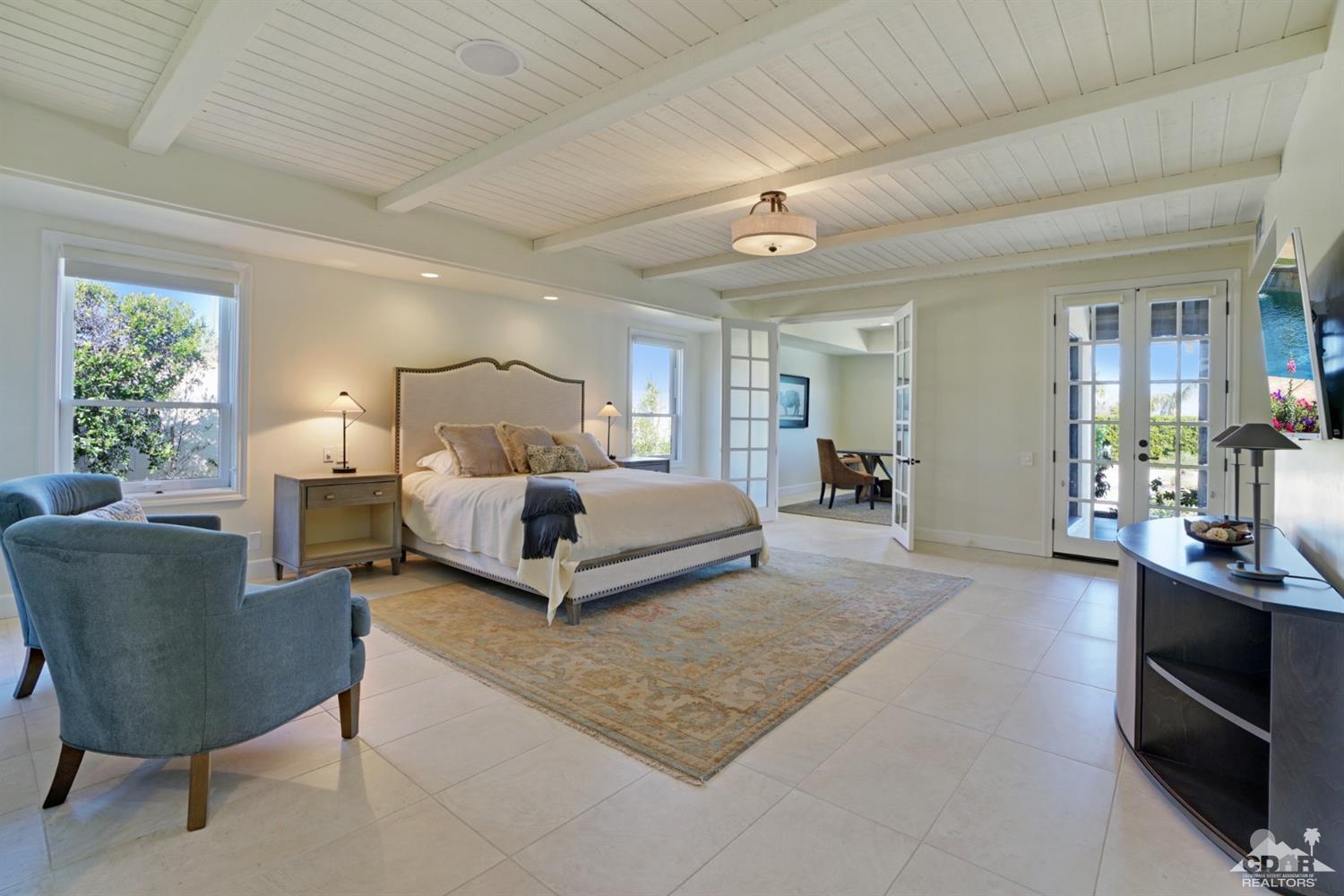 40757 Thunderbird Road Rancho Mirage, CA 92270 - Photo 37 of 70 a spacious bedroom with a bed a table and chair