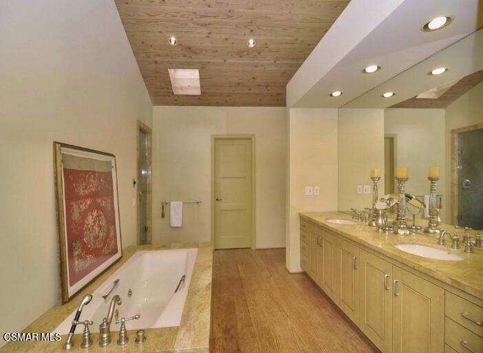 5537 Round Meadow Road Hidden Hills, CA 91302 - Photo 11 of 17 a spacious bathroom with a double vanity sink and a mirror