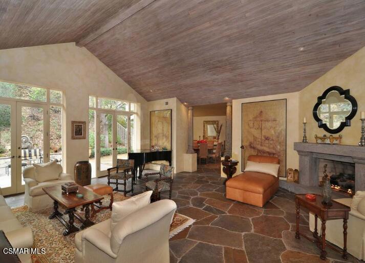 5537 Round Meadow Road Hidden Hills, CA 91302 - Photo 4 of 17 a living room with furniture a fireplace a rug and a large window