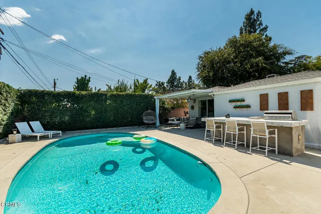 a view of a house with backyard sitting area and garden