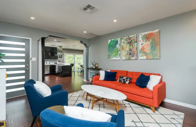 a living room with furniture and a wooden floor