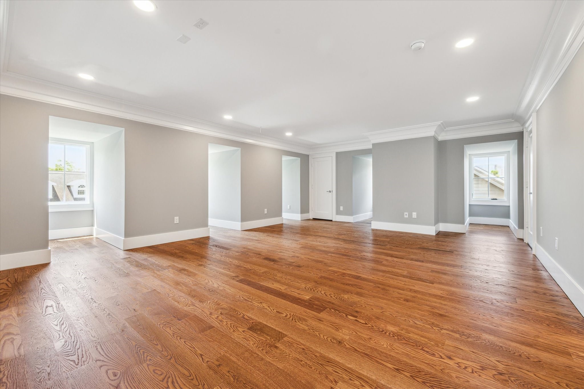 2216 Tangley Street Houston, TX 77005 - Photo 41 of 44 This view of this spacious 3rd floor flex/media/game room features beautiful hardwood floors, soft gray walls, and abundant natural light from multiple windows. The recessed lighting and crown molding add a touch of elegance, perfect for a versatile living space. There are also 2 large closets.