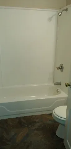 a bathroom with a toilet and a bath tub