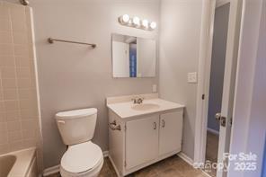 4814 Spring Lake Drive, Unit E Charlotte, NC 28212 - Photo 13 of 15 a bathroom with a toilet sink and mirror