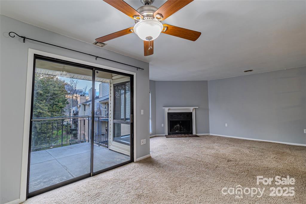 4814 Spring Lake Drive, Unit E Charlotte, NC 28212 - Photo 3 of 15 a view of an empty room with chandelier fan and fire place