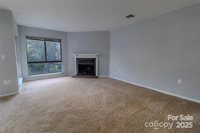 a view of empty room with a fireplace