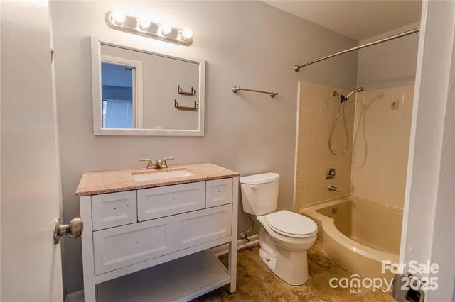 a bathroom with a granite countertop toilet sink and shower