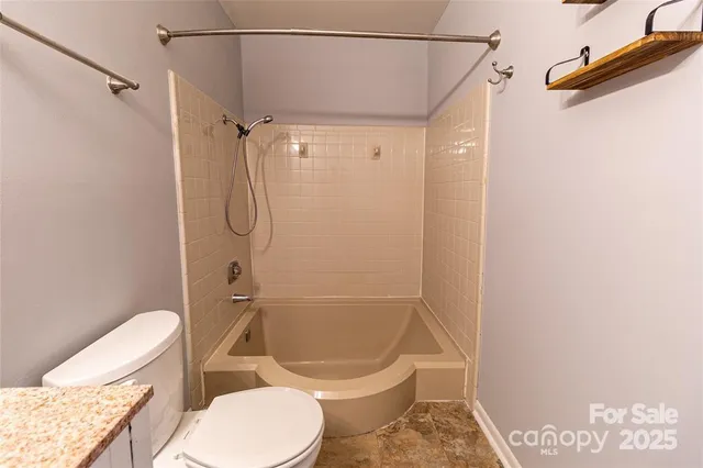 a white toilet sitting next to a bath tub and a shower