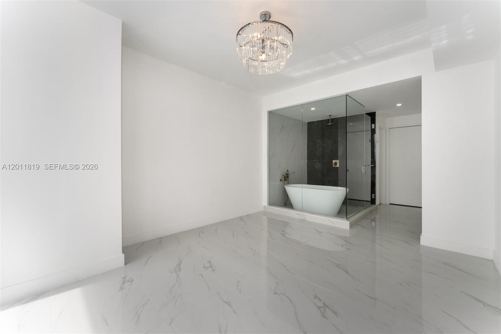 700 Northeast 24th Street, Unit 2504 Miami, FL 33137 - Photo 24 of 52 Serene primary suite offering unobstructed water views, direct terrace access, oversized walk-in closets, and floor-to-ceiling windows for a true 'mansion in the sky' feel.