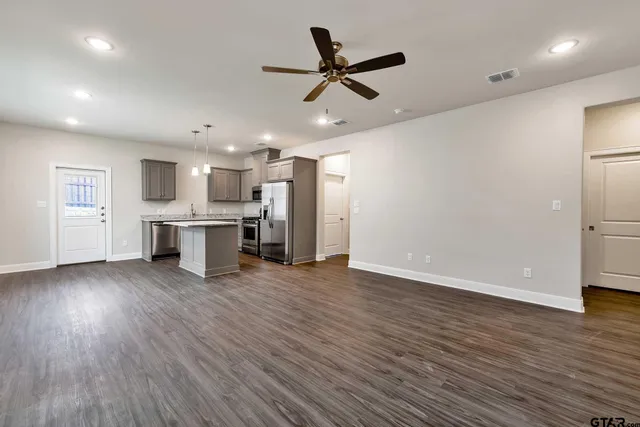 a view of a kitchen with a sink and dishwasher a refrigerator with wooden floor
