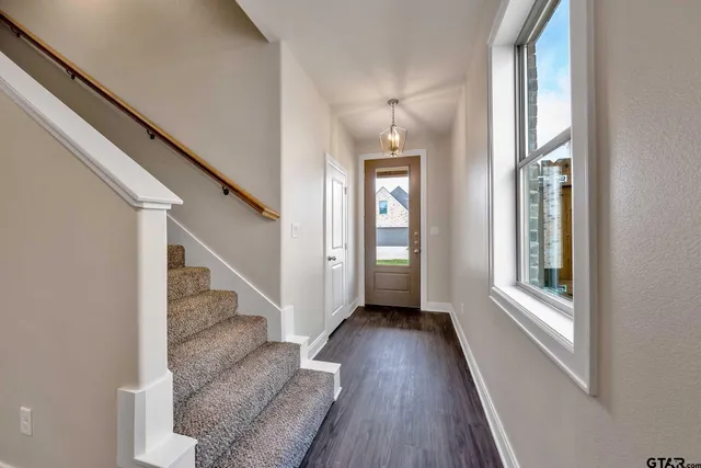 a view of entryway and hall with wooden floor