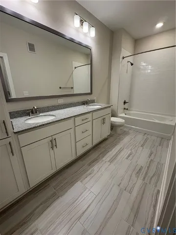 a bathroom with a double vanity sink and a mirror