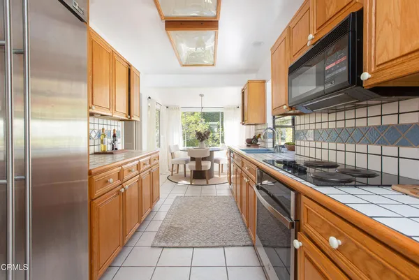 a kitchen with stainless steel appliances granite countertop a sink and a refrigerator