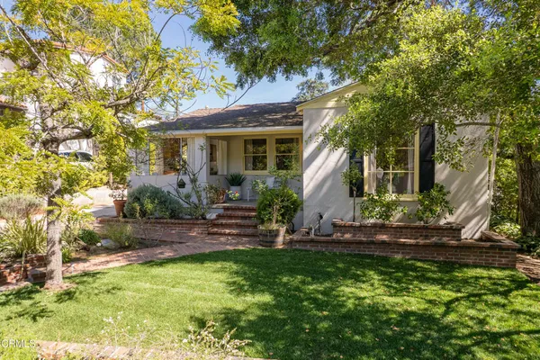 a view of a house with backyard and sitting area