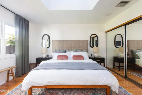 a bedroom with a large bed and wooden floor