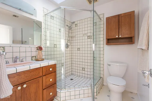 a bathroom with a sink toilet vanity and shower