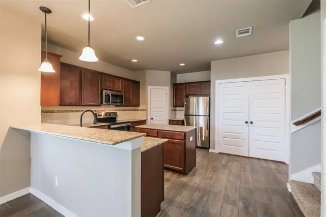a kitchen with refrigerator cabinets and wooden floor