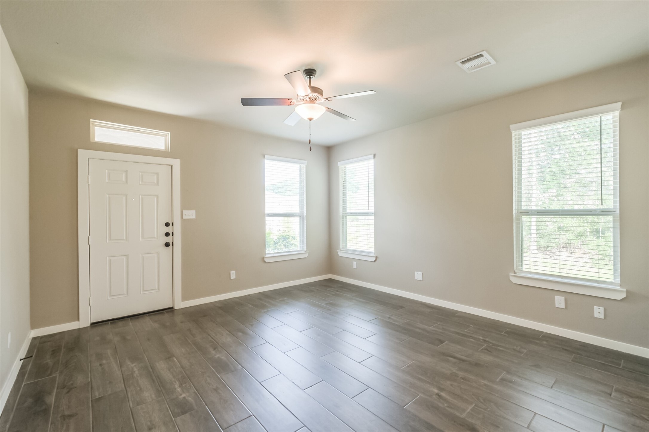 121 Wickersham, Unit A Conroe, TX 77304 - Photo 15 of 37 a view of an empty room with wooden floor and a window