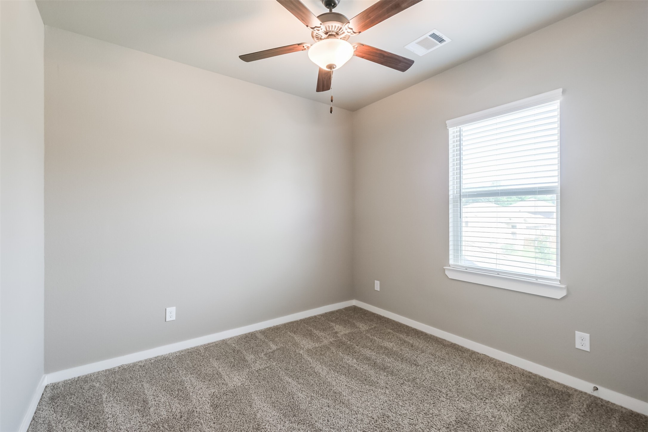 121 Wickersham, Unit A Conroe, TX 77304 - Photo 23 of 37 an empty room with a window and a fan