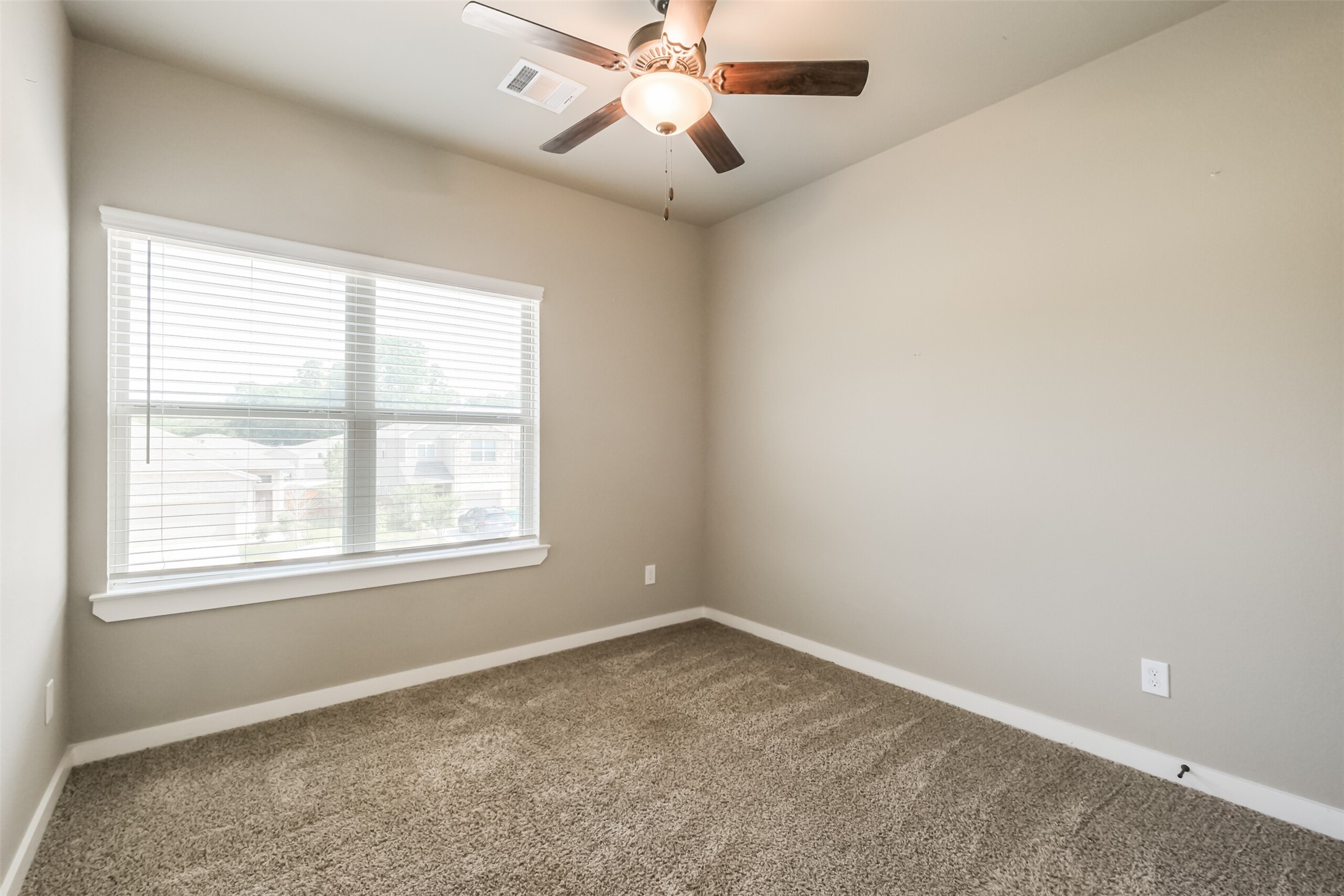 121 Wickersham, Unit A Conroe, TX 77304 - Photo 25 of 37 an empty room with a window and a fan