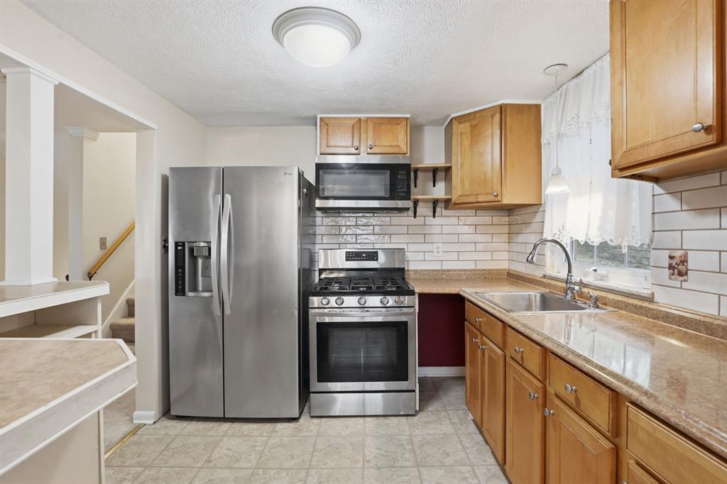 268 Plummer Avenue Pittsburgh, PA 15202 - Photo 16 of 50 a kitchen with stainless steel appliances granite countertop a refrigerator and a sink
