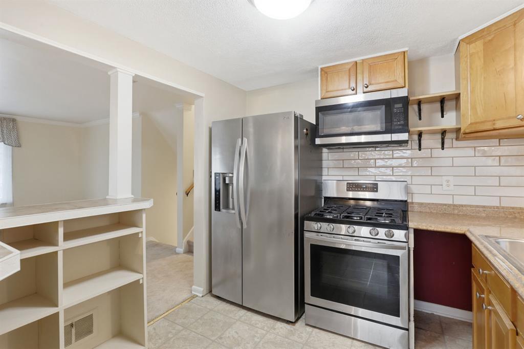 268 Plummer Avenue Pittsburgh, PA 15202 - Photo 18 of 50 a kitchen with granite countertop a stove microwave and refrigerator
