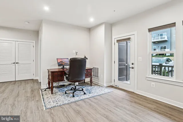a view of a workspace with furniture and wooden floor