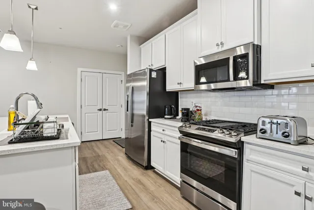 a kitchen with white cabinets stainless steel appliances and sink