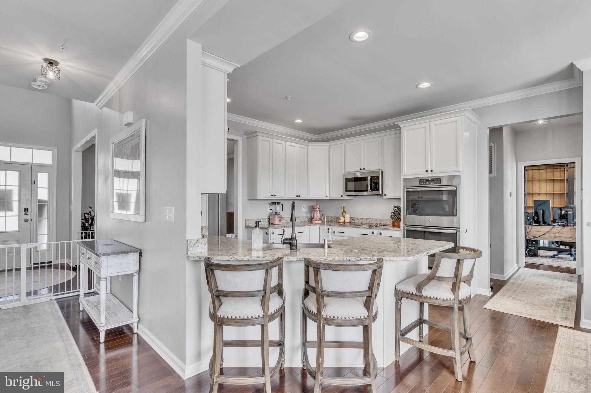 1935 Lowery Road Huntingtown, MD 20639 - Photo 13 of 65 a kitchen with stainless steel appliances kitchen island granite countertop a dining table chairs and white cabinets
