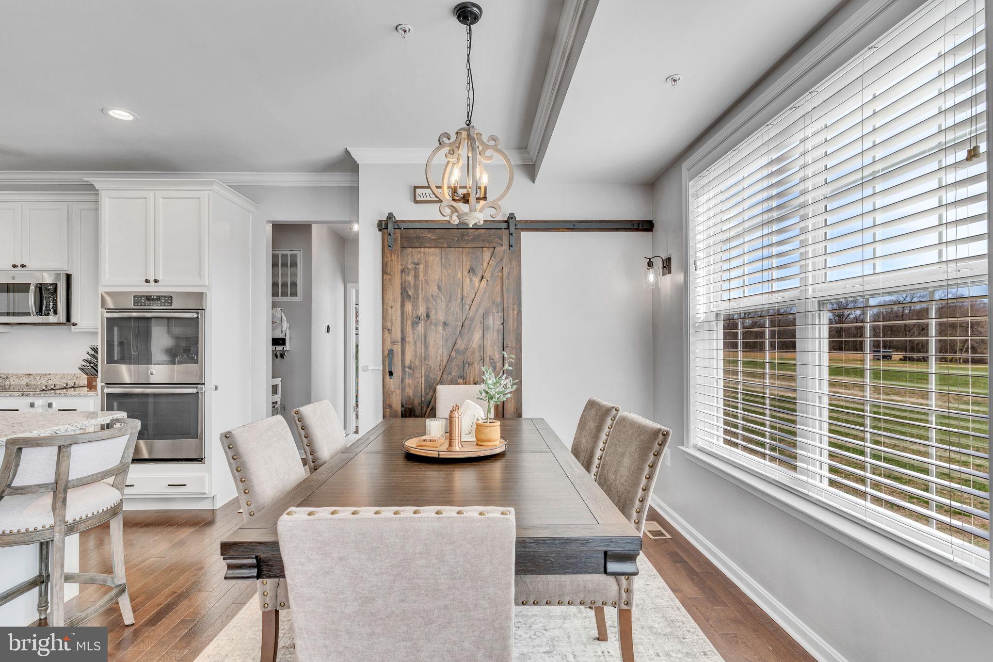 1935 Lowery Road Huntingtown, MD 20639 - Photo 22 of 65 a view of a dining room with furniture large windows and wooden floor