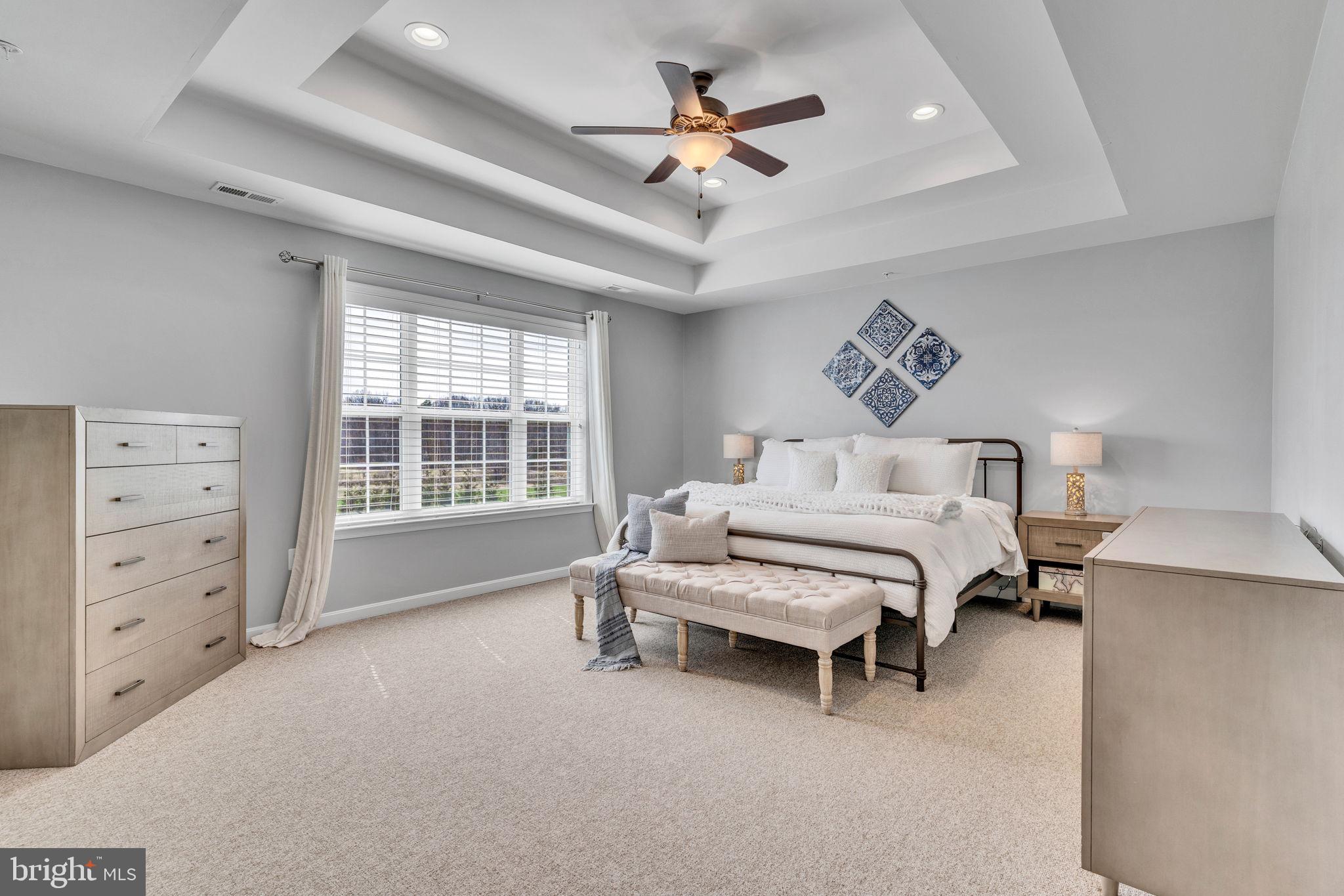1935 Lowery Road Huntingtown, MD 20639 - Photo 44 of 65 a spacious bedroom with a bed a chandelier and a window