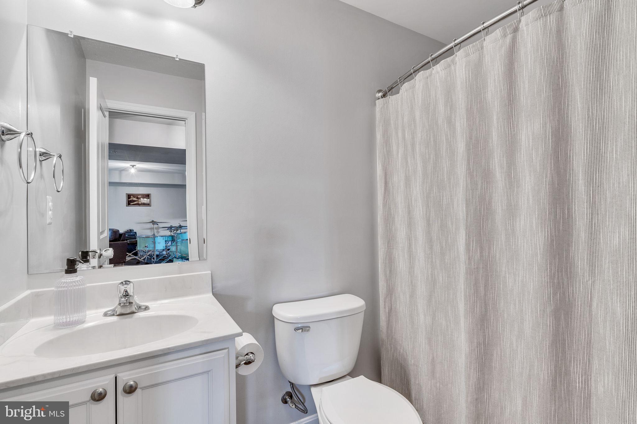 1935 Lowery Road Huntingtown, MD 20639 - Photo 60 of 65 a bathroom with a sink a toilet and shower curtain