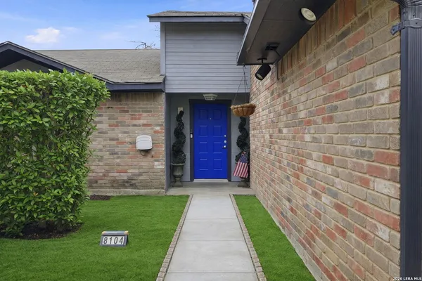 a view of brick house with a yard