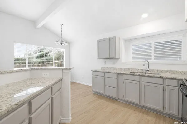 a kitchen with granite countertop sink and window