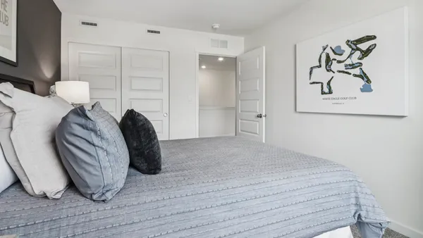 a bedroom with a bed and a painting on the wall