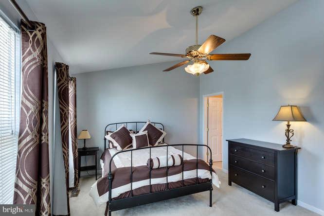21053 Cornerpost Square Ashburn, VA 20147 - Photo 17 of 30 a bedroom with a bed and a chandelier