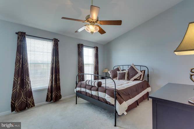21053 Cornerpost Square Ashburn, VA 20147 - Photo 18 of 30 a bedroom with a bed and a chandelier