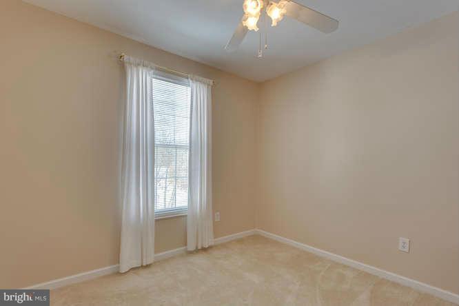 21053 Cornerpost Square Ashburn, VA 20147 - Photo 21 of 30 an empty room with a chandelier fan and windows