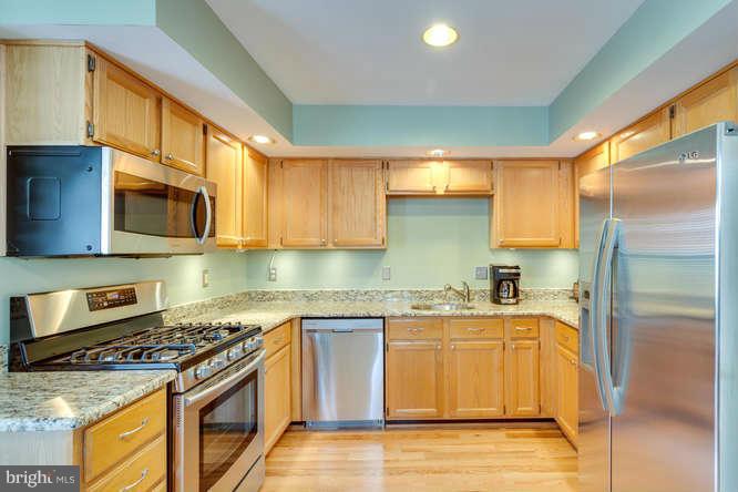 21053 Cornerpost Square Ashburn, VA 20147 - Photo 8 of 30 a kitchen with stainless steel appliances granite countertop a stove a sink and a microwave