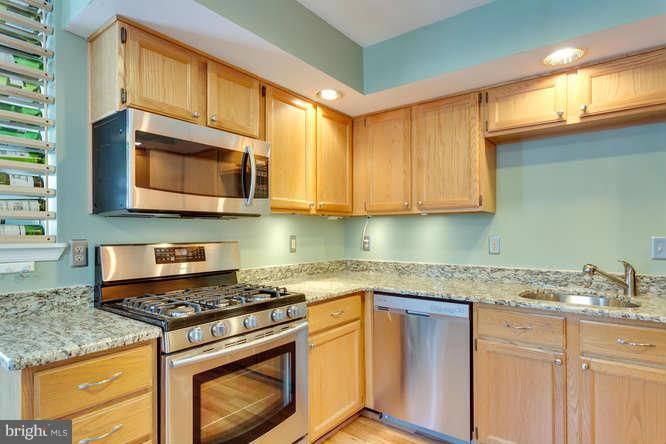 21053 Cornerpost Square Ashburn, VA 20147 - Photo 9 of 30 a kitchen with stainless steel appliances granite countertop a stove microwave and cabinets