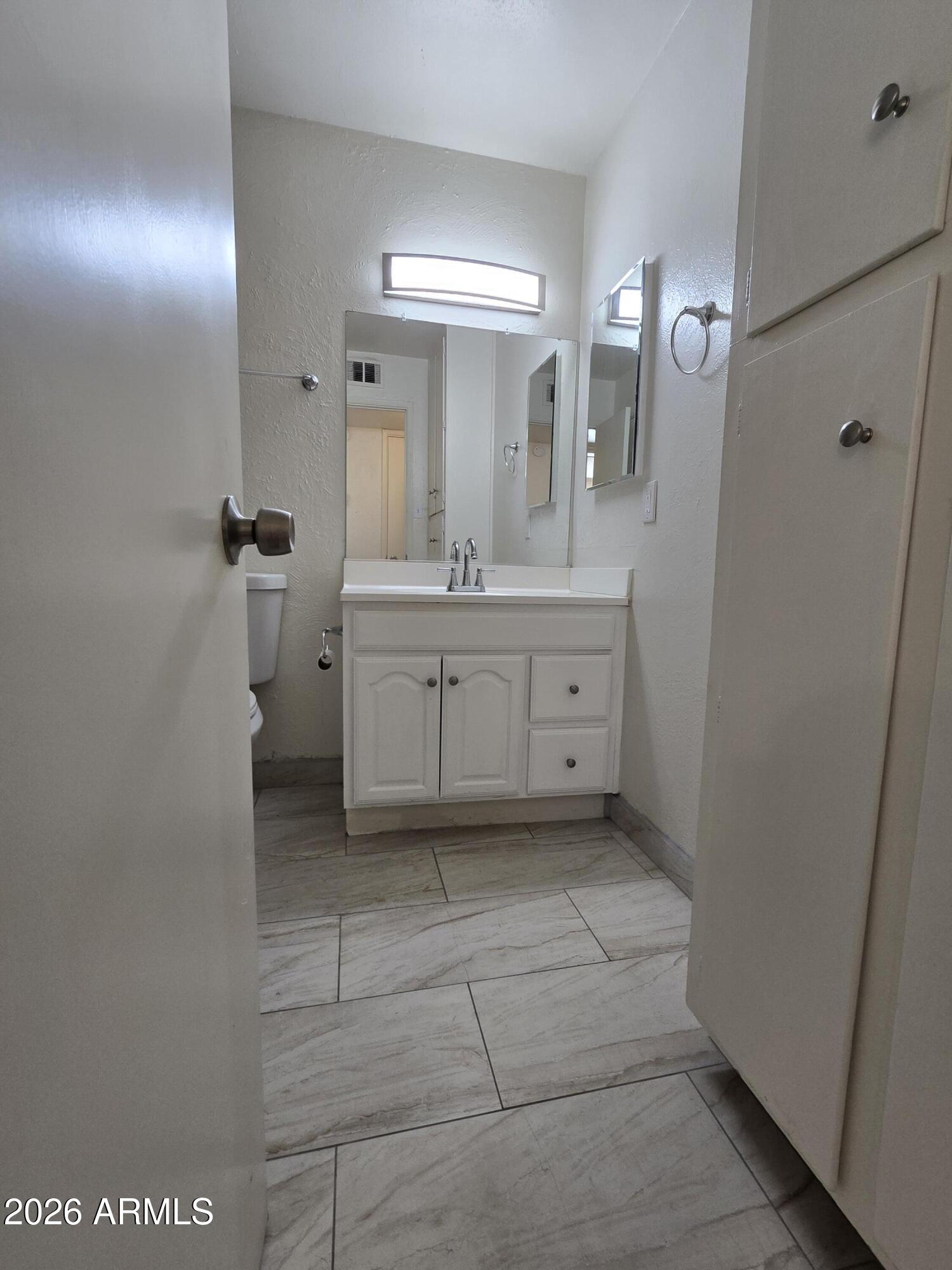 6512 North 41st Avenue Phoenix, AZ 85019 - Photo 16 of 24 a bathroom with a sink a mirror and a shower